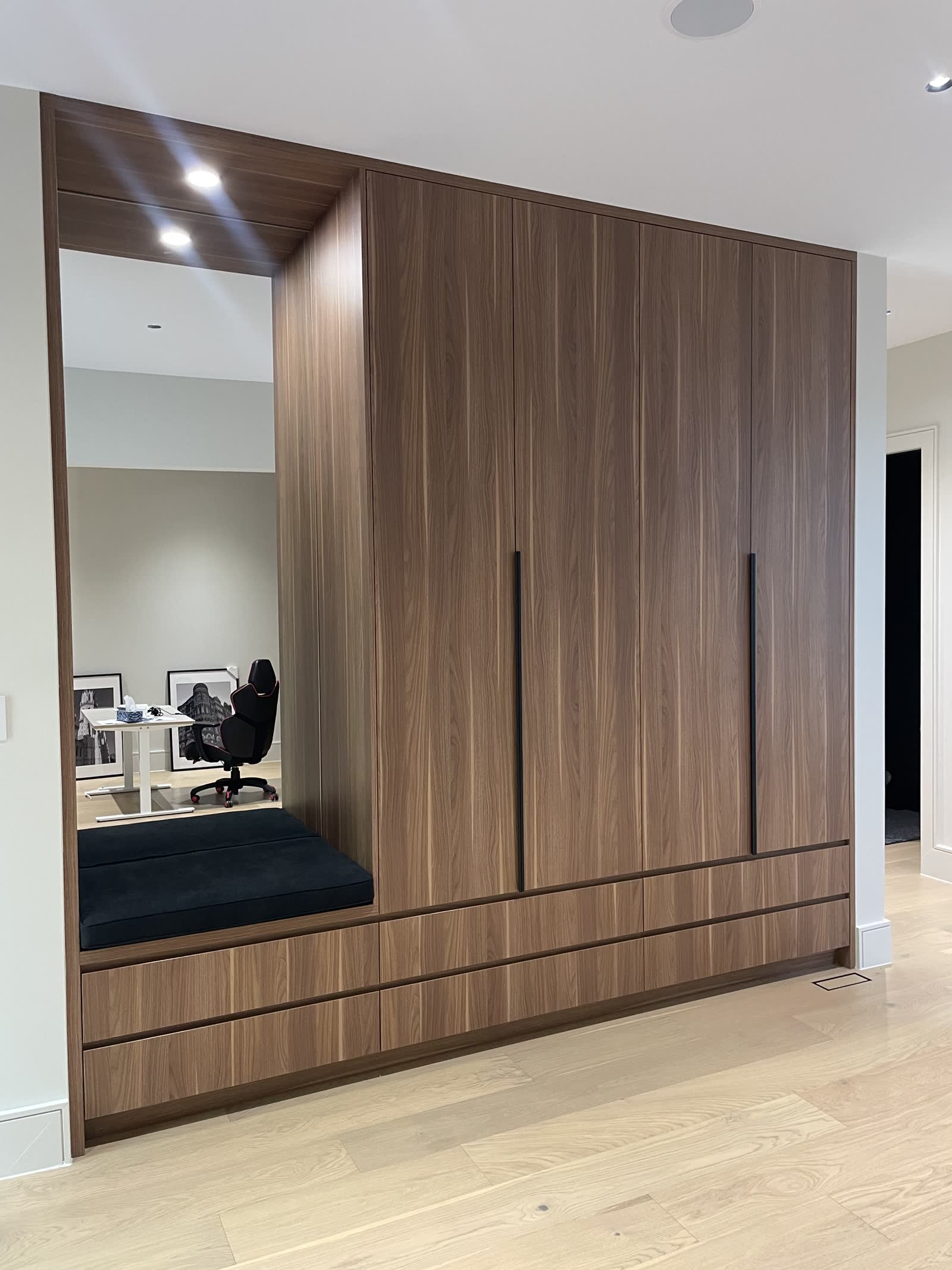 Walnut wardrobe wall with a built-in bench nook