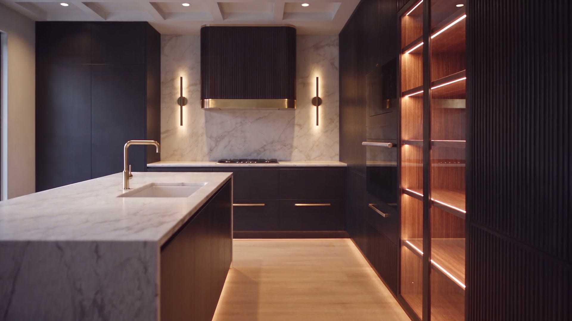 A finished custom kitchen at night with the integrated lighting on